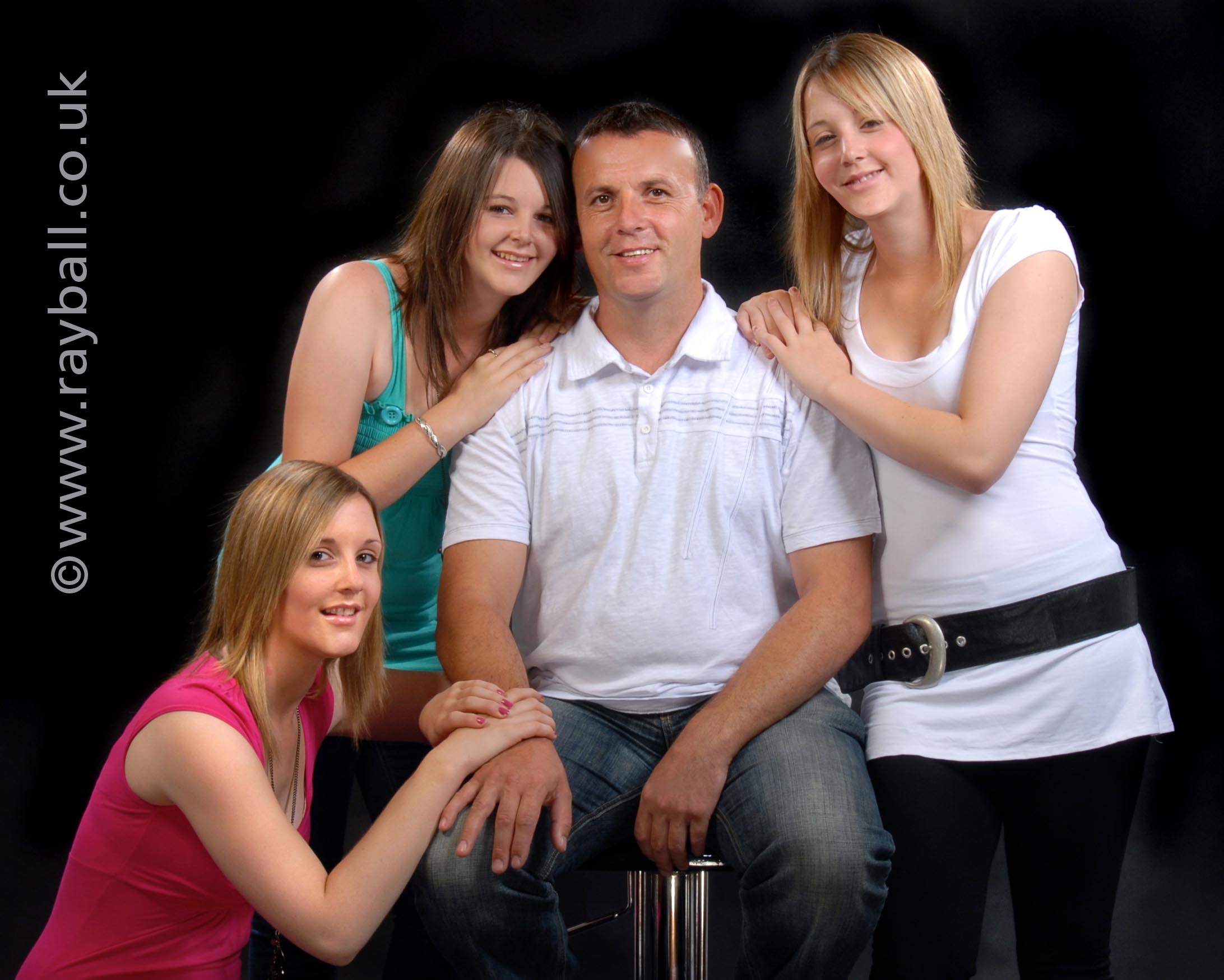 Studio portrait of three daughters and their dad from Sutton.