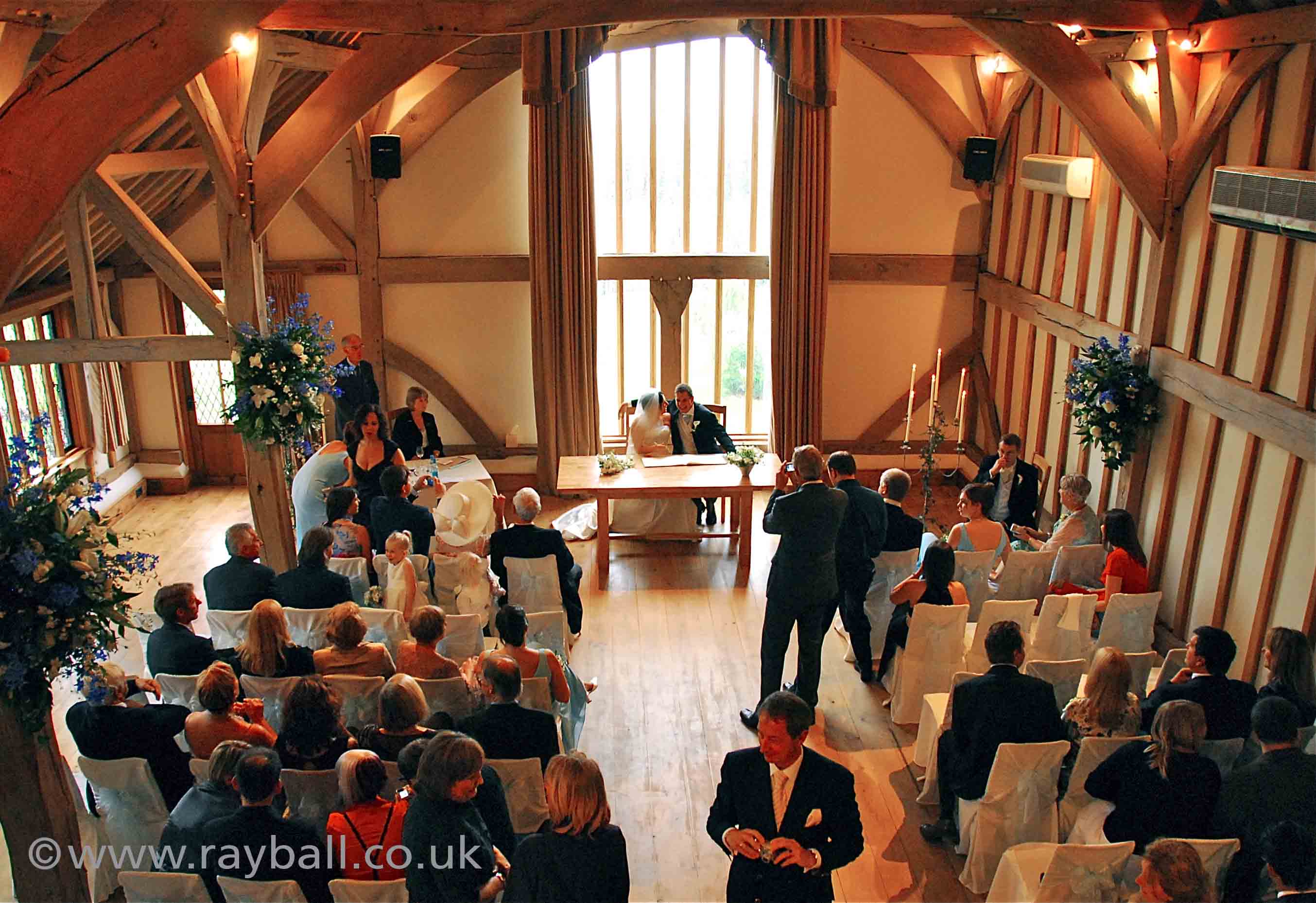 Newlyweds at register table with congregation Esher Surrey.